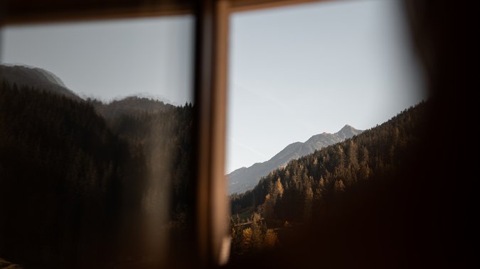 Blick durch ein Fenster auf die Kitzbüheler Alpen in Tirol Blick durch ein Fenster auf die Kitzbüheler Alpen in Tirol
