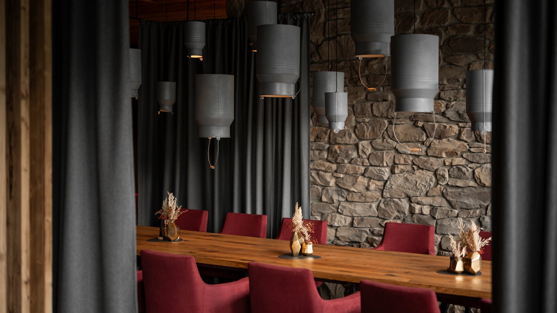 Moderner Essbereich mit roten Stühlen und Milchkannen, die von der Decke hängen im Restaurant UPSIDEDOWN in Fieberbrunn Moderner Essbereich mit roten Stühlen und Milchkannen, die von der Decke hängen im Restaurant UPSIDEDOWN in Fieberbrunn