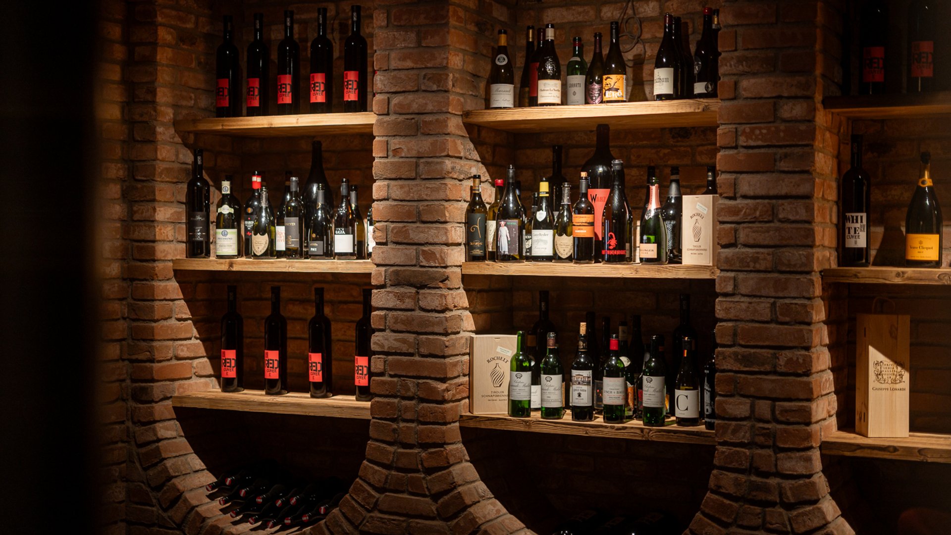 Weinlounge im Restaurant UPSIDEDOWN in Fieberbrunn mit gefüllten Weinregalen Weinlounge im Restaurant UPSIDEDOWN in Fieberbrunn mit gefüllten Weinregalen