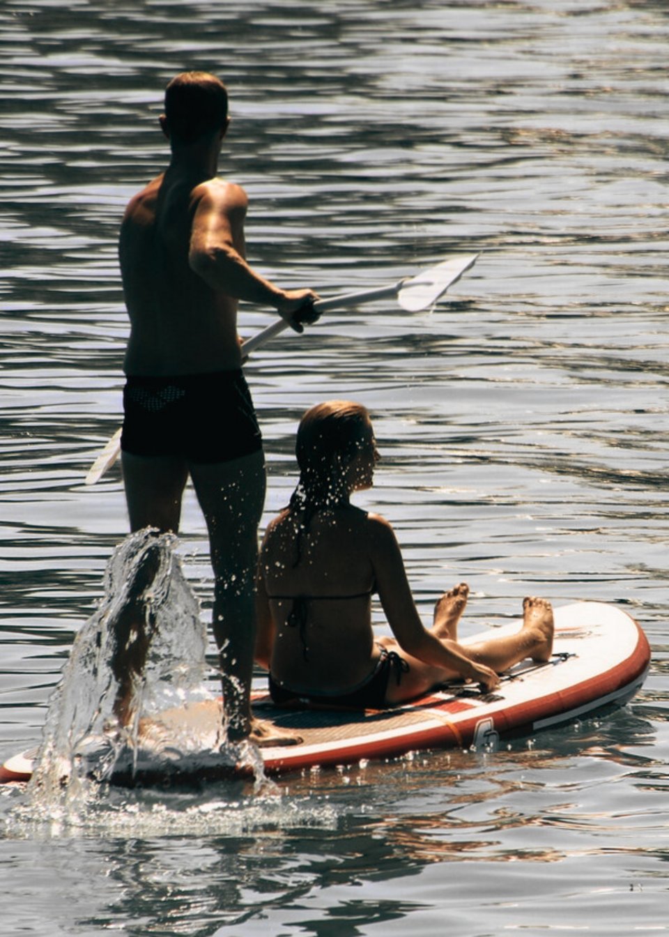 Zwei Personen auf einem Stand-up Paddleboard im Pillersee Zwei Personen auf einem Stand-up Paddleboard im Pillersee
