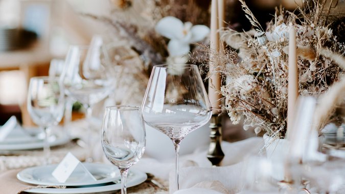Hochzeitslocation in Tirol: ADEA Lifestyle Suites Eleganter gedeckter Tisch mit Gläsern, Kerzen und Trockenblumen als Dekoration