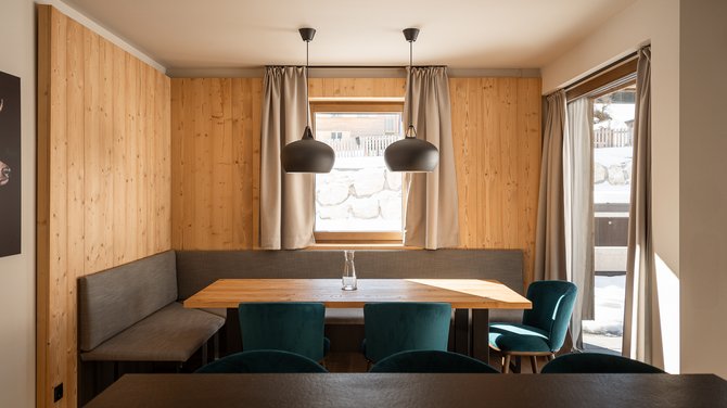 Moderner Essbereich mit Holzwänden und einem großen Esstisch in der Lodge Arkadia Moderner Essbereich mit Holzwänden und einem großen Esstisch in der Lodge Arkadia