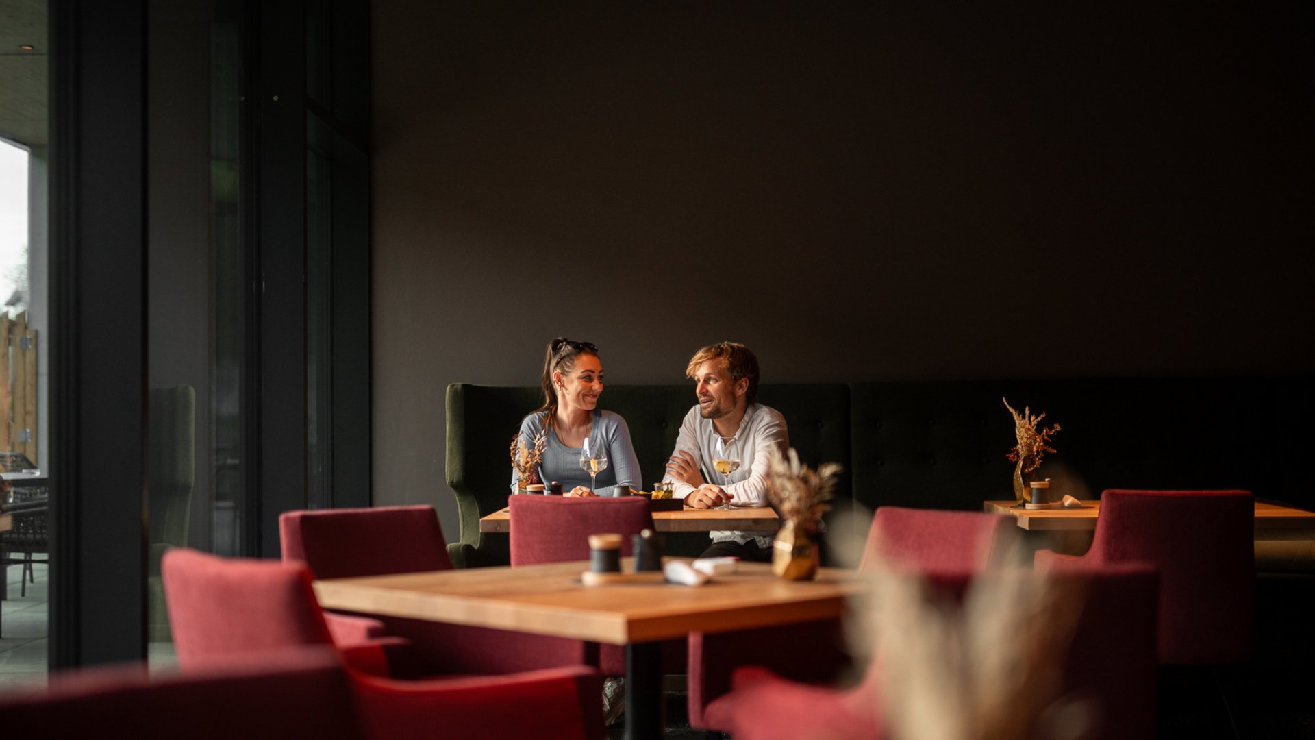 Paar sitzt an einem Tisch im Restaurant UPSIDEDOWN in Fieberbrunn und redet glücklich miteinander Paar sitzt an einem Tisch im Restaurant UPSIDEDOWN in Fieberbrunn und redet glücklich miteinander