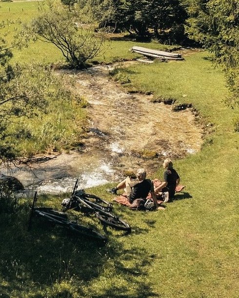 Paar genießt die Auszeit und sitz gemütlich vor einem Bach Paar genießt die Auszeit und sitz gemütlich vor einem Bach