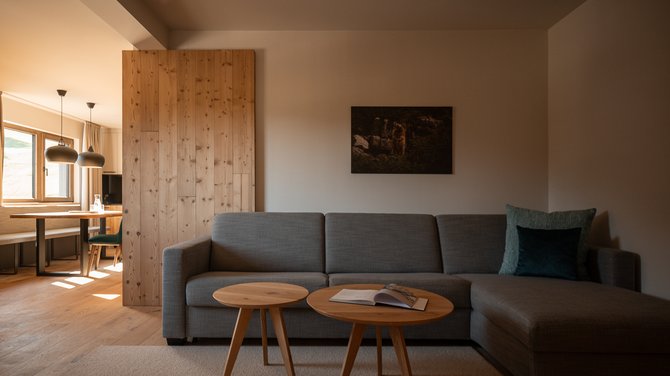 geräumiges Wohnzimmer in der Suite Fortuna Fireside Deluxe mit grauem Sofa und Couchtische geräumiges Wohnzimmer in der Suite Fortuna Fireside Deluxe mit grauem Sofa und Couchtische