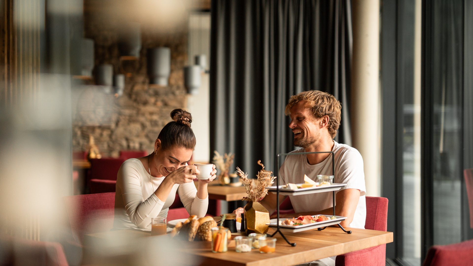 Paar lacht beim Frühstück im Restaurant UPSIDEDOWN Paar lacht beim Frühstück im Restaurant UPSIDEDOWN