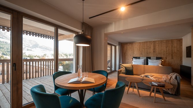 Urlaub für... Gemütliches Wohnzimmer mit Essbereich, Sofa und großem Fenster mit Bergblick