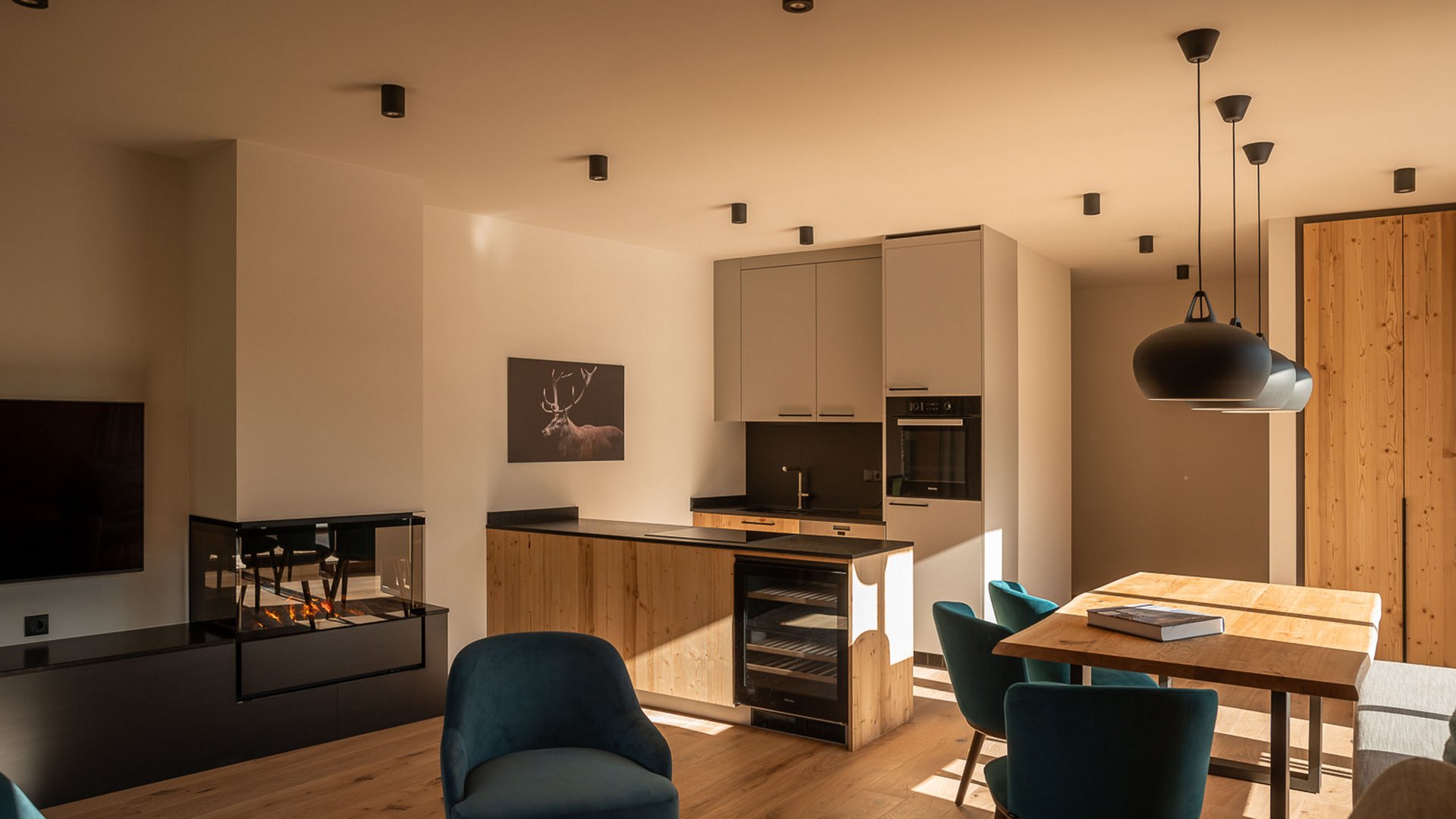 Luxus in der Ferienwohnung in Fieberbrunn Moderner Küchen- und Essbereich mit Holzdetails und Kamin