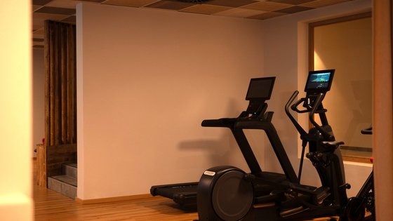 Fieberbrunn: Wellnesshotel gesucht? Fitnessraum mit Laufband und Ellipsentrainer auf Holzboden