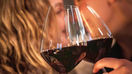 Hotel in Fieberbrunn: ADEA Lifestyle Suites Zwei Menschen stoßen mit Rotweingläsern an und lächeln sich an